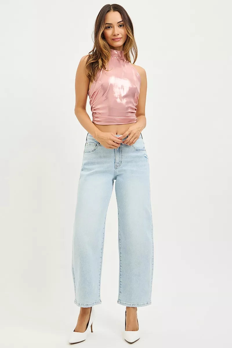 Model wearing high-rise barrel jeans styled with a minimalist knit top