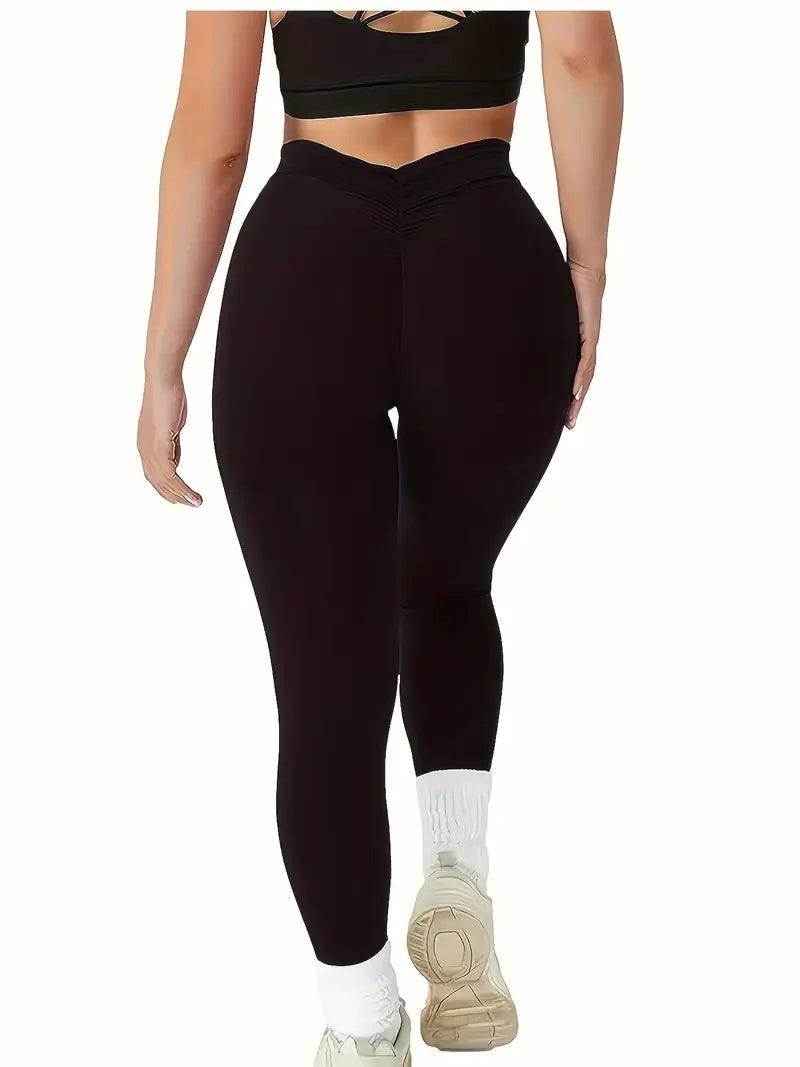 Full-length profile of black high-rise workout leggings with moisture-wicking fabric, paired with white athletic sneakers