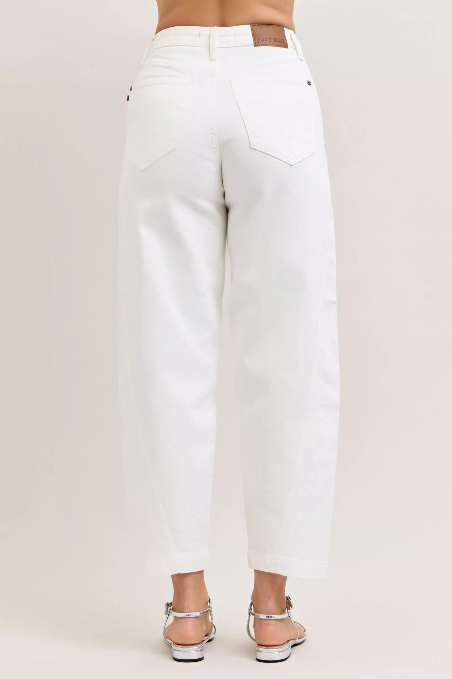 Model wearing high-waisted barrel leg jeans styled casually