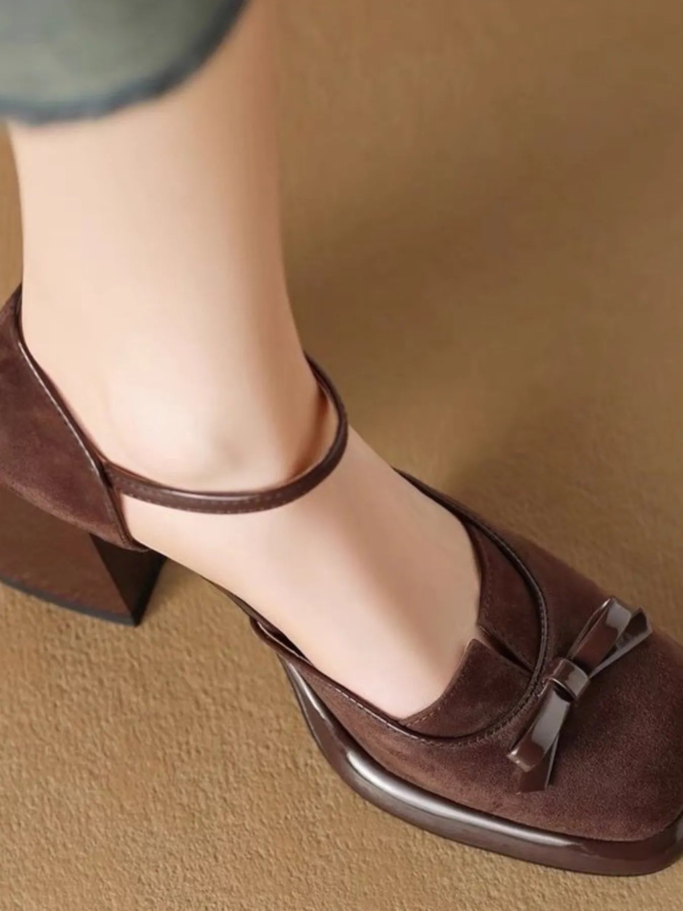 Close-up of the delicate bow embellishment and secure ankle strap construction