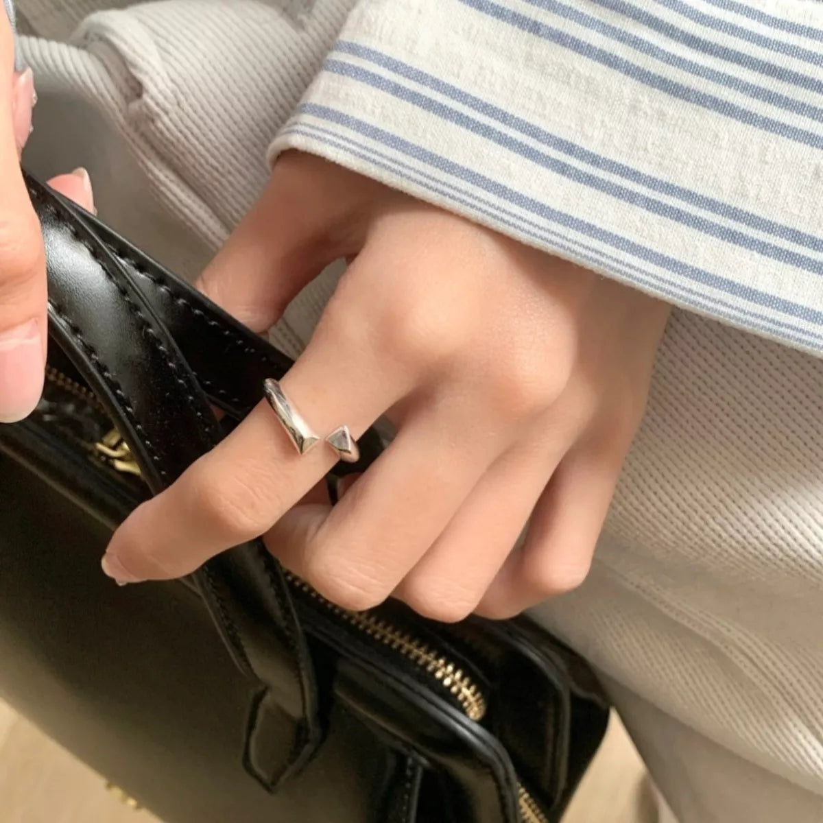 Model wearing the silver bypass ring styled for a professional, minimalist look
