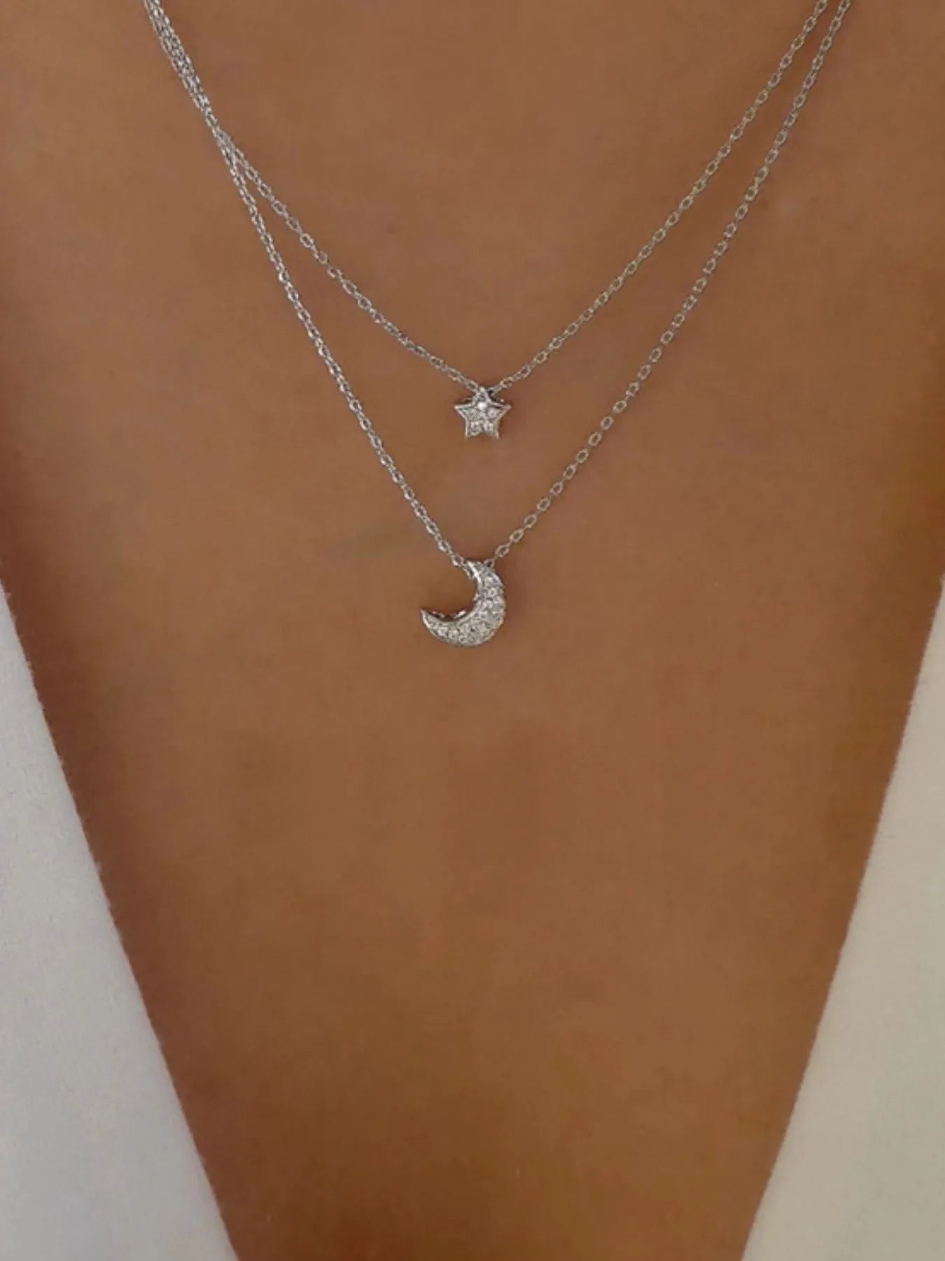 Model wearing the layered celestial necklace styled for a sophisticated evening event