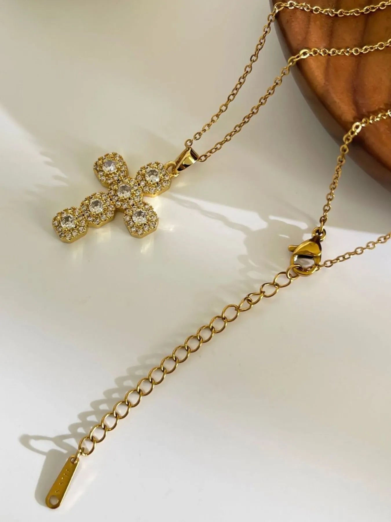 Model wearing the zircon cross necklace styled with a structured blazer