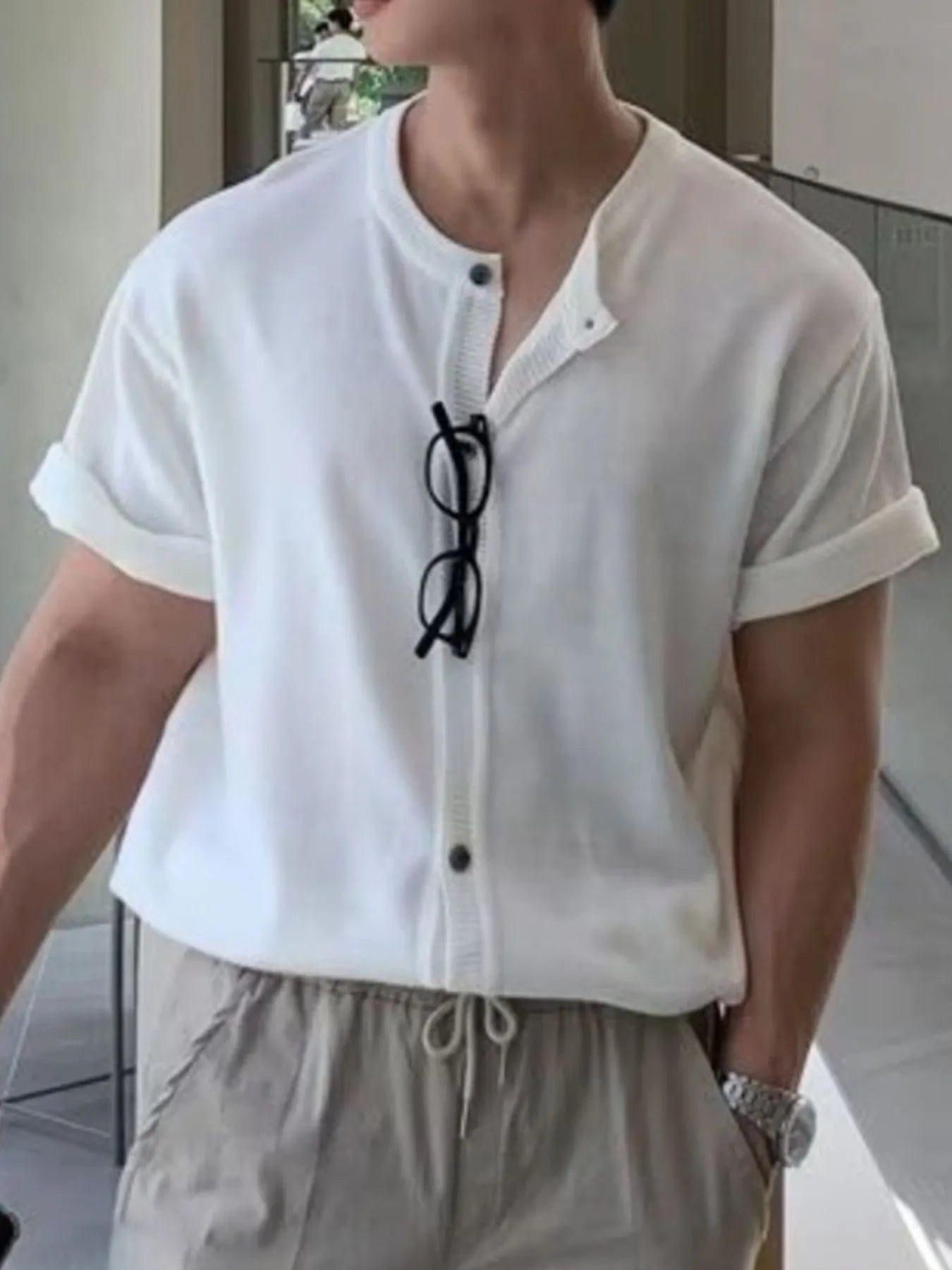 Model wearing buttoned drawstring short sleeve top styled casually
