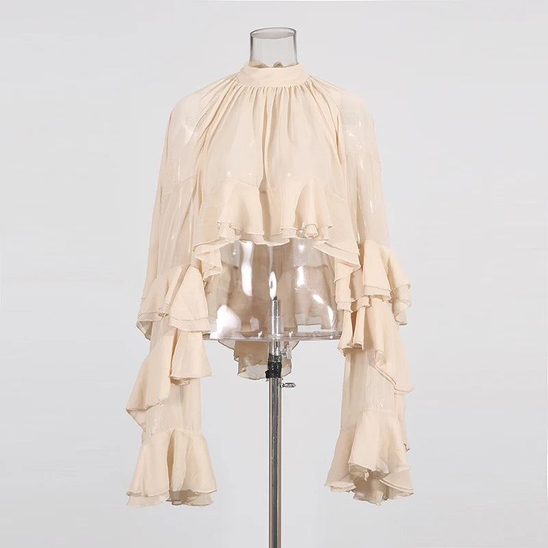 Styled outfit with high-neck sheer blouse paired with tailored pants for spring summer