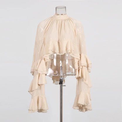 Styled outfit with high-neck sheer blouse paired with tailored pants for spring summer