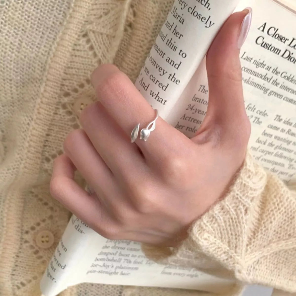 Model wearing the silver flower bypass ring styled for an upscale garden event