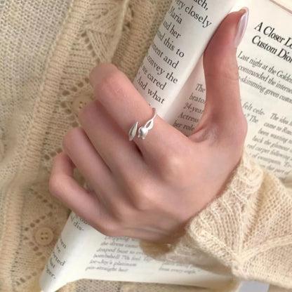 Model wearing the silver flower bypass ring styled for an upscale garden event