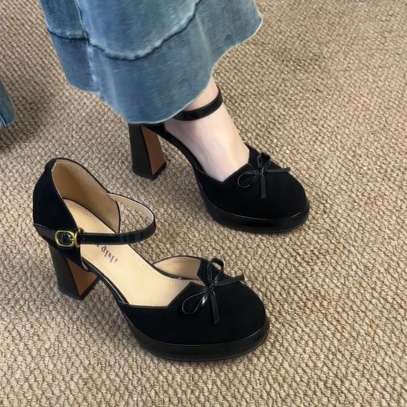 Front view of the black suede high heels with decorative bow-tie detailing