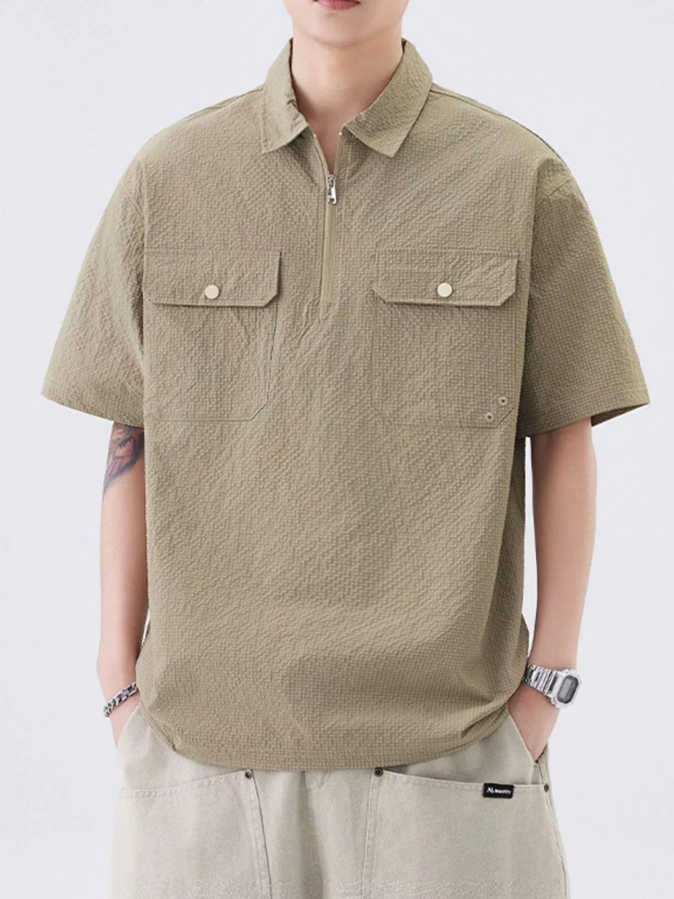 Close-up of half-zip closure and chest pocket on polo shirt