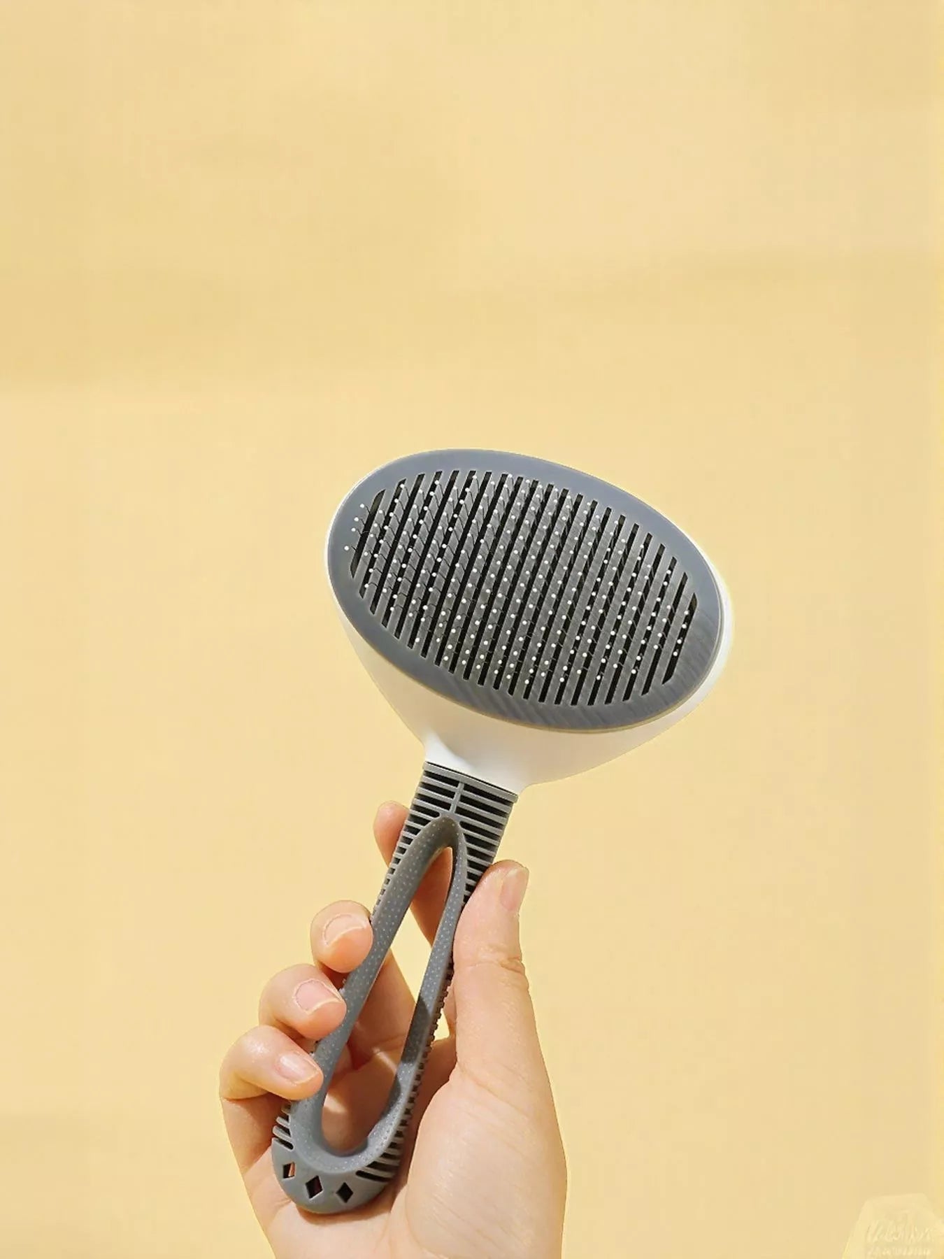 Close-up of bristle design and self-cleaning mechanism on pet brush