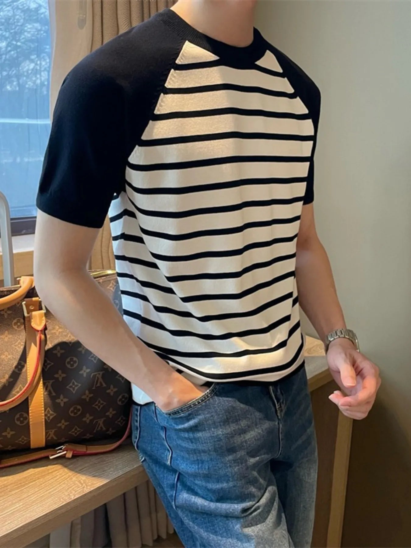 Model wearing striped raglan sleeve T-shirt styled casually