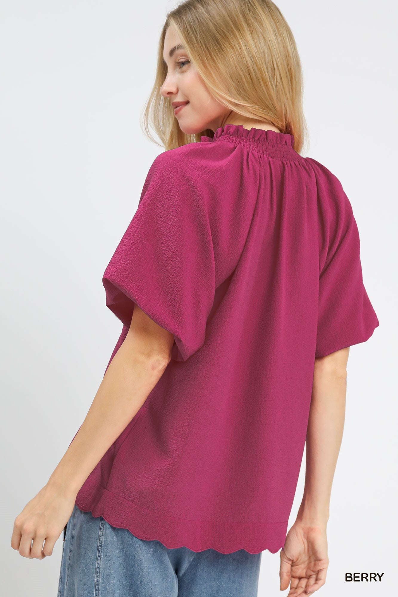 Model wearing scalloped hem textured blouse styled casually