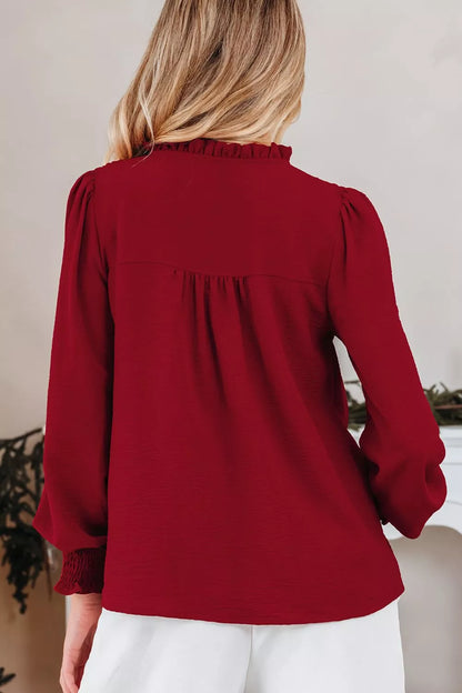 Model wearing the notched neck blouse styled with high-waist trousers