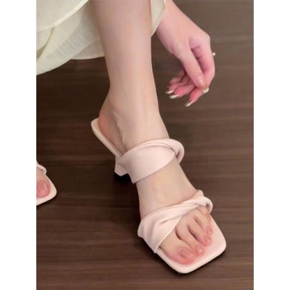 Model wearing the one-line sandals styled with a silk dress in a high-profile luxury setting