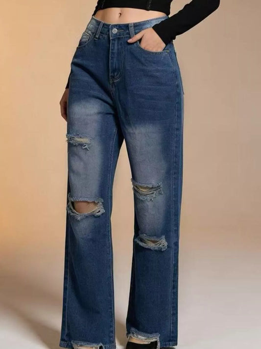Model wearing distressed wide leg jeans styled for an urban streetwear look