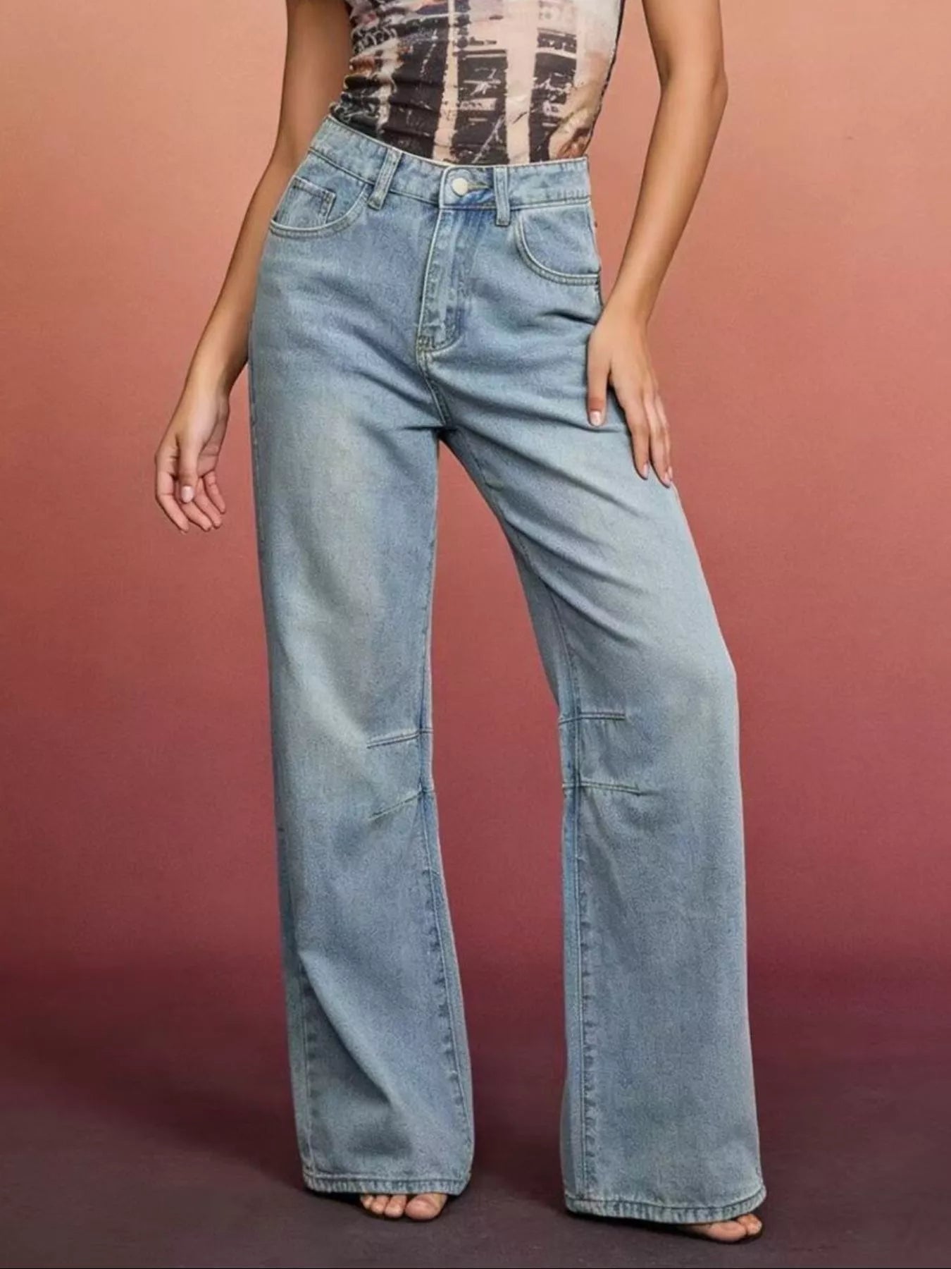Model wearing washed wide leg denim jeans styled casually