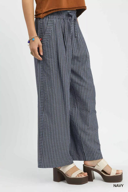 Model wearing striped drawstring pants styled for a resort-inspired look