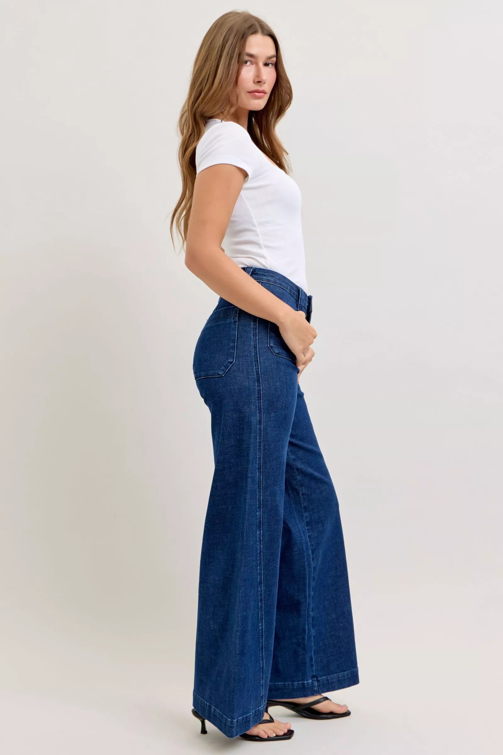 Model wearing retro wide leg jeans with a bohemian blouse and boots
